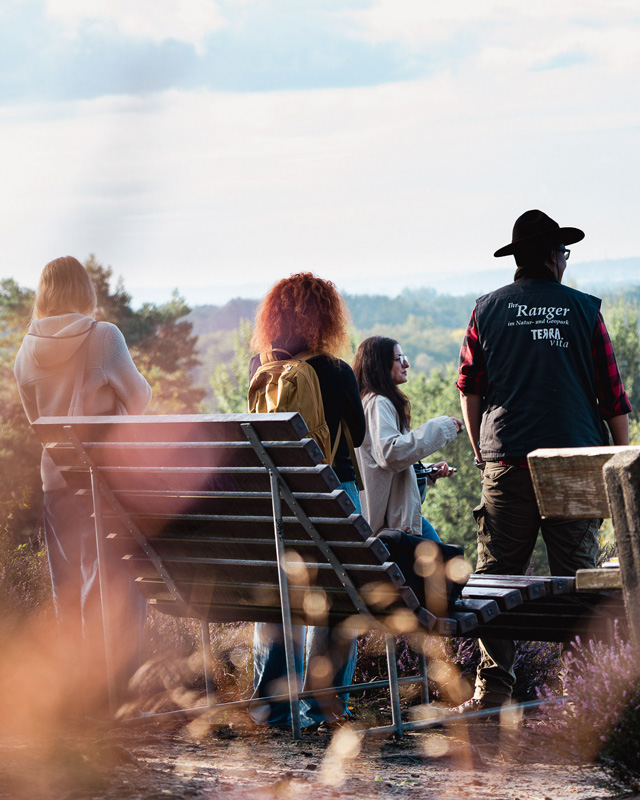 Wandergruppe mit 4 Personen an Rastplatz mit Ranger TERRAvita
