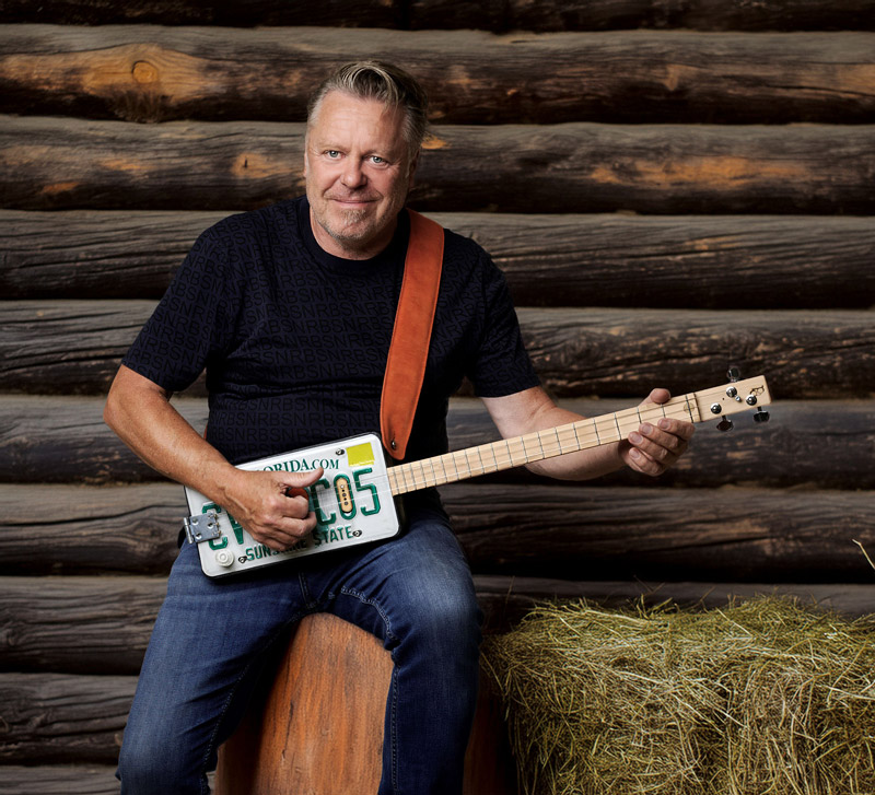 Der Musiker Richie Arndt vor einer Holzwand